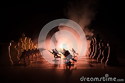 War concept. Silhouettes of soldiers on chessboard. War Concept. Military silhouettes fighting scene on war fog sky background, Ch Stock Photo