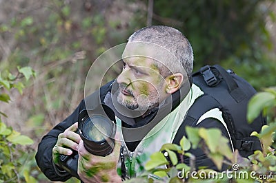 War photographer camouflaged in the vegetation Stock Photo