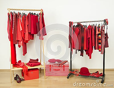 Wardrobe with red clothes hanging on a rack nicely arranged. Stock Photo