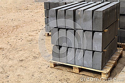 Warehouse of cement pressed materials on wooden pallets. Large pile of grey slabs and curbs for work at construction Stock Photo