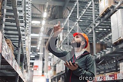 Warehouse manager checking his inventory in a large warehouse Stock Photo