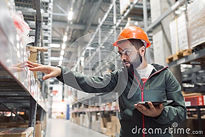 Warehouse manager checking his inventory in a large warehouse Stock Photo