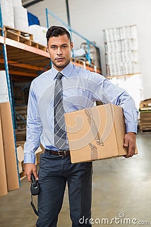 Warehouse manager holding cardboard box and scanner Stock Photo