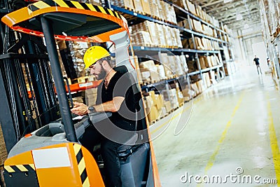 Warehouse worker doing logistics work with forklift loader Stock Photo