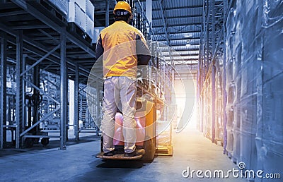 Warehouse Worker Driving Electric Forklift Pallet jack. Package Boxes in Storage Warehouse with Tall Shelves. Stock Photo