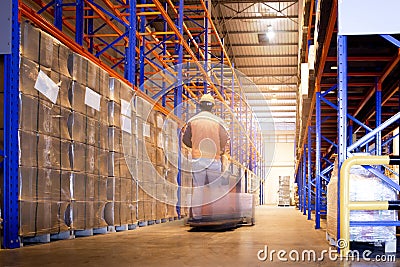 Warehouse worker driving forklift unloading shipment goods. Stock Photo