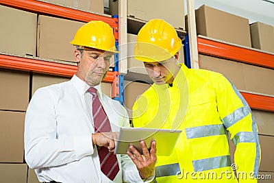 Warehouse Worker And Manager Looking At Laptop Stock Photo