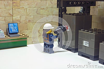 Warehouse worker, reading a label automatically with a reader device on packages stored on a warehouse shelf Editorial Stock Photo