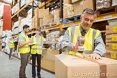 Warehouse worker sealing cardboard boxes for shipping Stock Photo