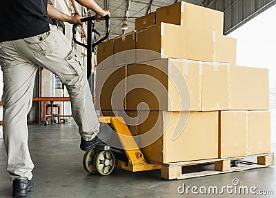 Warehouse worker working with hand pallet truck unloading shipment goods at warehouse Stock Photo