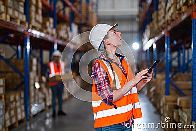 Warehouse worker working process checking the package using a tablet in a large warehouse distribution center Stock Photo