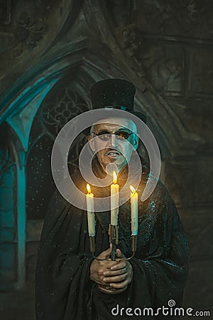Warlock male with a candelabra in hand. Stock Photo
