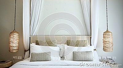 Warm atmosphere around bedroom in resort style hotel with white bedsheet, set of pillows on bed Stock Photo