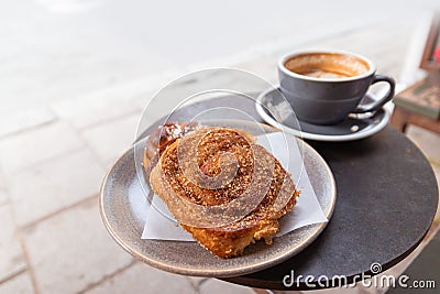 Warm cinnamon bun with icing sugar with cup of coffee Stock Photo