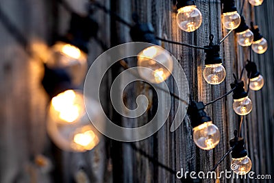 Warm color LED light bulbs on old wooden background in the garden, copyspace, outdoor lighting deciration concept Stock Photo