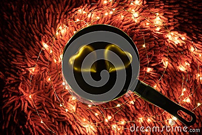 A warm color light garland surrounding two hearts inside pan. valentine`s day Stock Photo