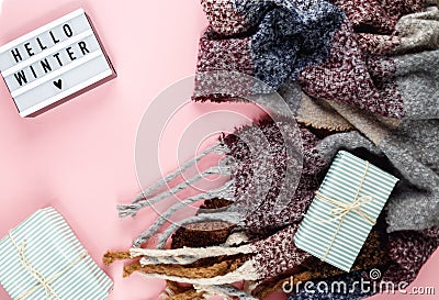 Warm, cozy winter clothing, scarf, lightbox on pastel pink background. hello winter title Stock Photo