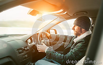 Warm dressed Bearded Man driving a new modern auto. Inside car v Stock Photo