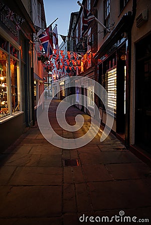 Warm glow of shop lights on Sandgate at night. Whitby, North Yorkshire. Editorial Stock Photo