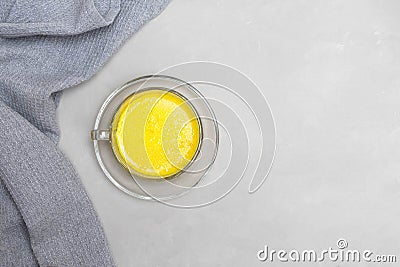 Warm homemade turmeric golden milk in a glass cup on grey neutral background Stock Photo