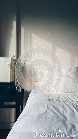 Warm morning light over white fluffy bed Stock Photo