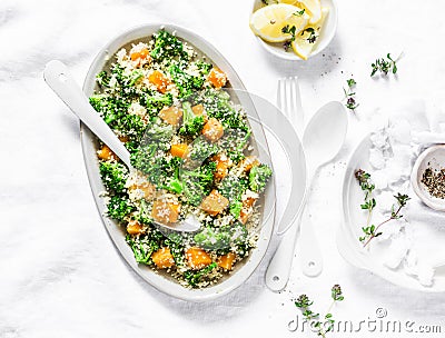 Warm salad with broccoli, pumpkin and couscous on a light background, top view. Vegetarian food concept. Stock Photo