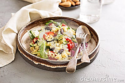 Warm salad with bulgur, vegetables and leaves Stock Photo