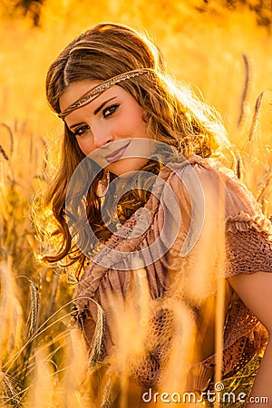 Warm summer haze seventies hippie girl in grainfield. Stock Photo