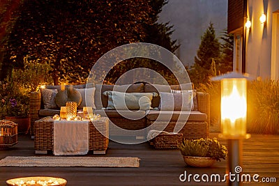 Summer night in the garden with trendy furniture, lights, lanterns and candles Stock Photo