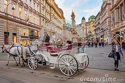 Warm sunset over busy with tourists famous Graben shopping street near Stephans square Stephansplatz with a horse drawn carriage Editorial Stock Photo