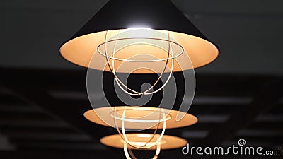 Warmes elektrisches Licht kommt von den dekorativen Lampen malte schwarz und orange auf einem dunklen Hintergrund, die über gereg stock footage Warmes elektrisches Licht kommt von den dekorativen Lampen malte schwarz und orange auf einem dunklen Hintergrund, die über gereg stock footage