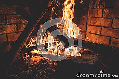 Warming up by the fire, cozy winter night in the cabin by the fireplace, fire burns in the scandinavian cottage, burning fire with Stock Photo