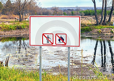 Warning banner on the shore of the pond with inscriptions prohibiting Smoking and bonfire in nature without text. Concept of nat Stock Photo