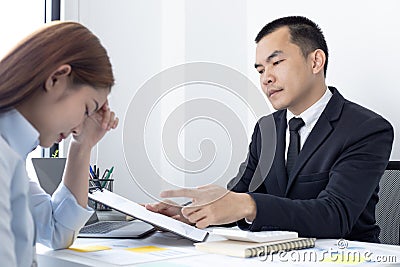 Warning offenders, supervisor in a black suit warns or scolds a woman finance worker for the wrong operation Stock Photo