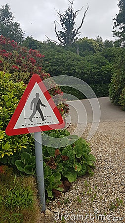 Warning pedestrian sign beside gravel driveway. Stock Photo