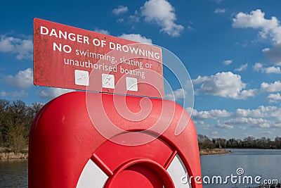 Life-ring rescue equipment seen stationed adjacent to a deep water lake. Editorial Stock Photo