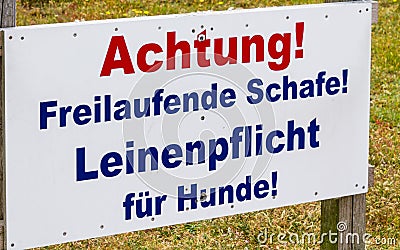 Sign `Freilaufende Schafe. Leinenpflicht fÃ¼r Hunde` warn in german about the danger meeting of dog and sheep on the Island Stock Photo
