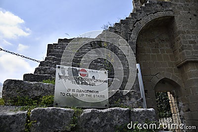 Warning sign on a old staircase of stone outside a old ruin Stock Photo