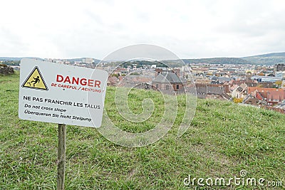 Warning sign to prevent tip over, overturn, in English, German and French language attached to wooden stick . Stock Photo