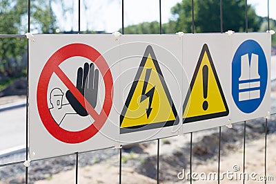 Warning signs on fence at construction site Stock Photo