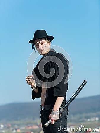 Warrior in black hat, tattooed torso in open clothes Stock Photo