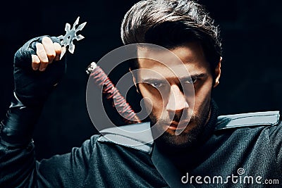 Warrior fighter with a sword and shuriken ready to stab enemy Stock Photo