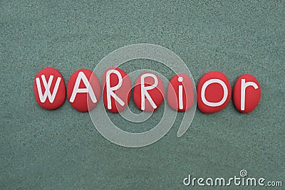 Warrior, motivational word composed with red colored stone letters over green sand Stock Photo