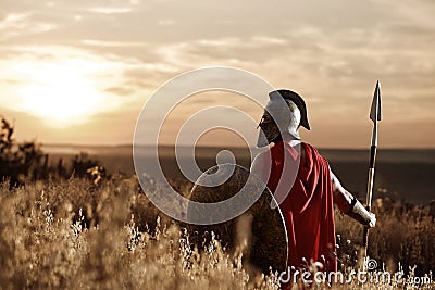 Warrior wearing iron helmet and red cloak. Stock Photo