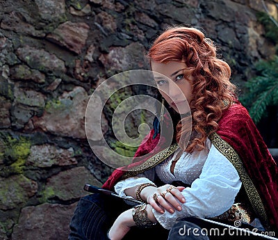 Warrior woman with sword in medieval clothes is very dangerous Stock Photo