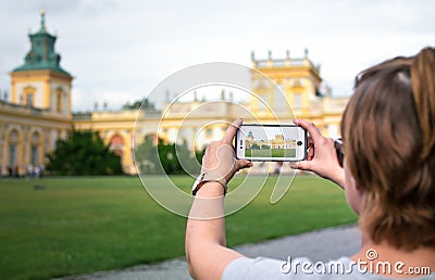 WARSAW, POLAND - AUGUST 11: A young woman photographing the royal Wilanow Palace in Warsaw Editorial Stock Photo