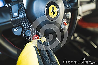 17.05.2023. Warsaw, Poland. cleaning Ferrari's steering wheel with a yellow cloth Editorial Stock Photo