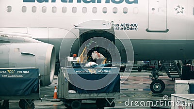 WARSAW, POLAND - DECEMBER 25, 2017. Loading mail onto the Lufthansa airplane at the Chopin international airport Editorial Stock Photo