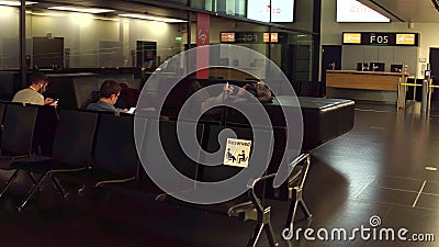 WARSAW, POLAND - DECEMBER, 24 Passengers at international airport terminal departure lounge. Reserved seats for pregnant Editorial Stock Photo