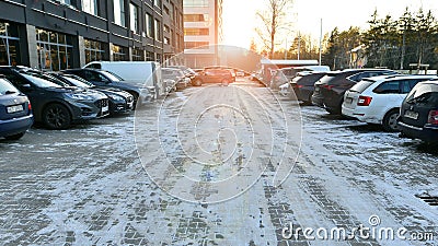 Warsaw, Poland. 8 January 2024. Cars parked in the snow covered parking lot in front of building on a sunny winter day. Editorial Stock Photo